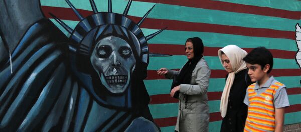 Uma família iraniana passa por pichações contrárias aos EUA na parede da antiga embaixada americana em Teerã. Uma família iraniana passa por pichações contrárias aos EUA na parede da antiga embaixada americana em Teerã. - Sputnik Brasil