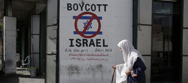 A Palestinian woman walks past a mural calling people to boycott Israeli goods in the al-Azzeh refugee camp near the West Bank city of Bethlehem on September 17, 2014 - Sputnik Brasil