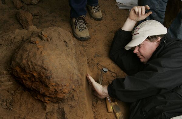 Pesquisador do Museu de Ciência Natural de Houston examina solo sob um meteoro - Sputnik Brasil