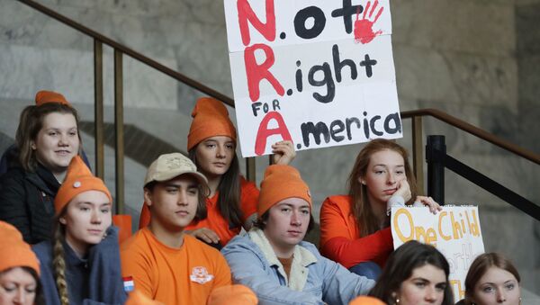 Estudante em Seattle segura uma placa que diz NRA - Not Right for America (NRA - Não é o melhor para América, em tradução livre) enquanto participa de uma manifestação contra a violência armada. - Sputnik Brasil