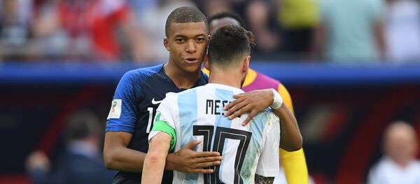 France's Kylian Mbappe, left, comforts Argentina's Lionel Messi after France's 4:3 victory in the World Cup Round of 16 soccer match between France and Argentina, at the Kazan Arena, in Kazan, Russia, June 30, 2018 - Sputnik Brasil