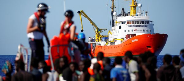 O navio Aquarius ao fundo enquanto imigrantes são resgatados pela organização SOS mediterrâneo. Foto de 14 de setembro de 2017. - Sputnik Brasil