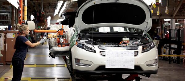 Membro do sindicato da United Auto Workers, Carrie Attwood, usa um braço ergonômico para instalar um banco dianteiro em um veículo elétrico Chevrolet Volt na fábrica da General Motors. - Sputnik Brasil