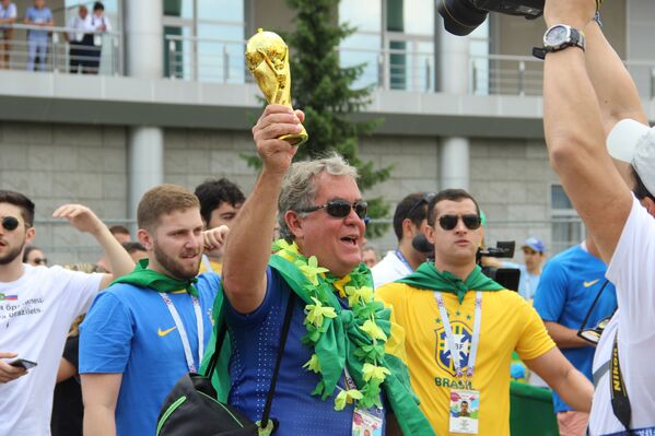 Torcedor brasileiro levanta réplica da taça ao dar boas-vindas à Seleção perto do hotel Mirage, em Kazan, em 5 de julho de 2018 - Sputnik Brasil