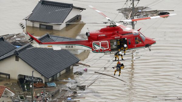 Visão aérea mostra o resgaste de um morador de área submersa por enchente em Kurashiki, região sul do Japão - Sputnik Brasil