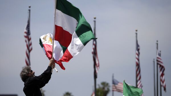 Um manifestante anônimo agitando bandeiras iranianas em Los Angeles, EUA (foto de arquivo) - Sputnik Brasil