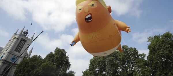 Um dirigível infantil de seis metros representando o presidente dos EUA, Donald Trump, é levado como protesto contra sua visita, ao Parliament Square, Londres. - Sputnik Brasil