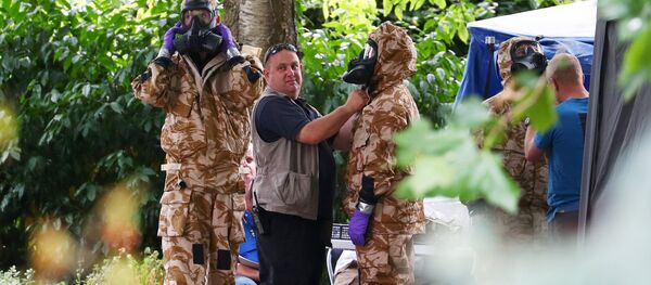 Investigadores vestem trajes militares de proteção contra materiais perigosos durante uma busca policial em Salisbury, Inglaterra. - Sputnik Brasil