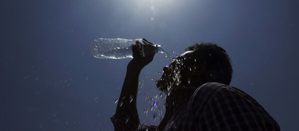 Homem derrama água no rosto durante um dia quente de verão em Hyderabad, Índia. - Sputnik Brasil