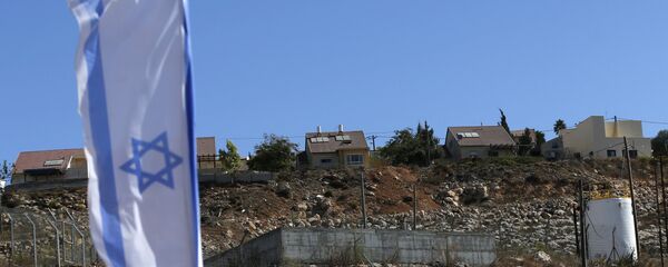 Bandeira nacional israelense que voa ao lado de um local de edifício israelita de unidades de alojamento novas no estabelecimento judaico de Shilo na Cisjordânia palestina ocupada. - Sputnik Brasil