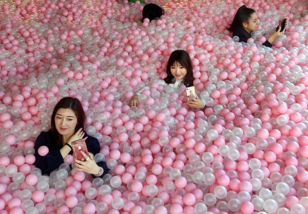 Visitantes do museu Sugar Republic (República do Açúcar) tirando selfies no meio de bolas parecidas com doces, em Melbourne, Austrália. - Sputnik Brasil