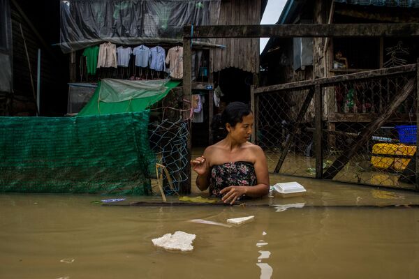 Mulher anda pela rua inundada na cidade de Bago, em Mianmar - Sputnik Brasil