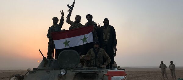 Forças sírias gesticulam enquanto carregam a bandeira nacional na vila de Suwayyah, perto da cidade fronteiriça com síria de Albu Kamal, em 9 de novembro de 2017 - Sputnik Brasil