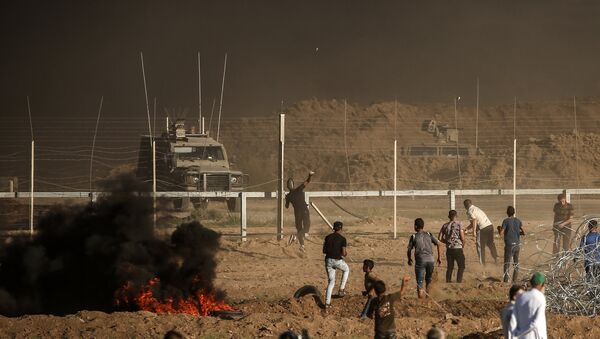 Manifestantes palestinos atiram pedras contra as forças israelenses durante uma manifestação na fronteira entre Israel e a Faixa de Gaza, a leste da cidade de Gaza em 27 de julho de 2018 - Sputnik Brasil