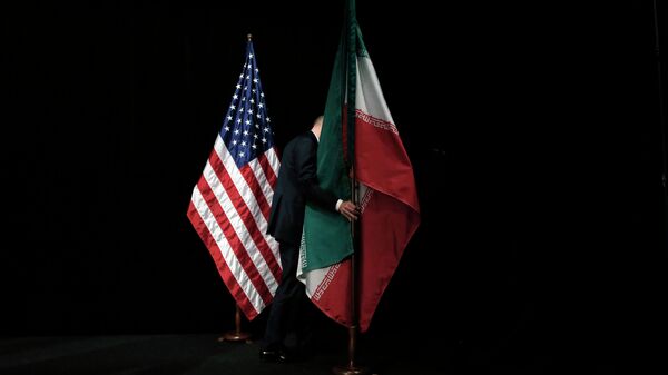 Um homem remove a bandeira iraniana do palco depois de uma foto de grupo com ministros das Relações Exteriores e representantes dos Estados Unidos, Irã, China, Rússia, Grã-Bretanha, Alemanha, França e União Europeia durante as conversações nucleares do Irã no Centro Internacional de Viena em Viena , Áustria (arquivo) - Sputnik Brasil