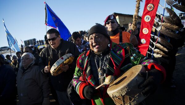 Dan Nanamkin, da tribo nativa norte-americana em Nespelem, Wash, comemoram com instrumentos uma procissão pelo acampamento Oceti Sakowin nos EUA, em 4 de dezembro de 2016 - Sputnik Brasil