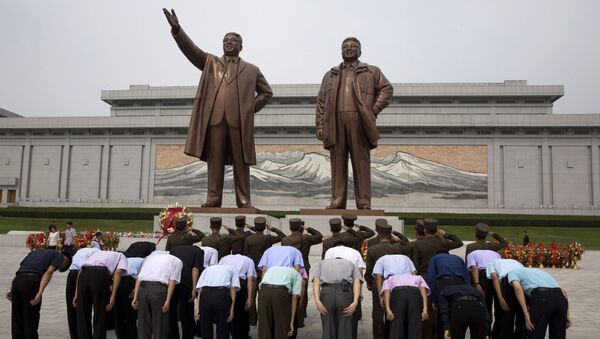Norte-coreanos se encurvam diante das estátuas dos líderes Kim Il-sung e Kim Jong-il (foto de arquivo) - Sputnik Brasil