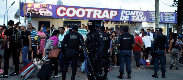 Policiais da tropa de choque conversam com pessoas da Venezuela depois de checar seus passaportes ou carteiras de identidade no controle de fronteira de Pacaraima, Roraima, Brasil - Sputnik Brasil