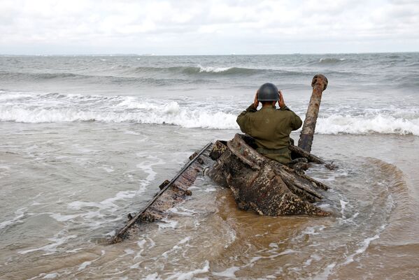 Homem vestido de uniforme militar posa para foto em um tanque abandonado na praia nas vésperas do 60º aniversário da Segunda Crise do Estreito de Taiwan, no arquipélago de Kinmen - Sputnik Brasil