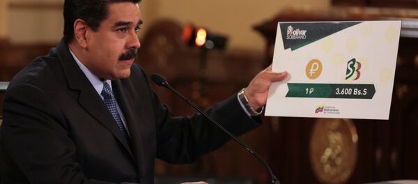 Presidente da Venezuela, Nicolás Maduro, segurando uma placa mostrando o valor de uma Petro em comparação com a nova moeda venezuelana, durante reunião com os ministros no Palácio de Miraflores em Caracas, Venezuela, em 17 de agosto de 2018 - Sputnik Brasil