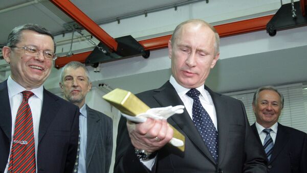 Presidente russo Vladimir Putin segurando uma barra de ouro enquanto visitava o Depositário Central do Banco da Rússia, em 24 de janeiro de 2011 - Sputnik Brasil