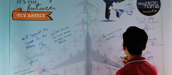 Um homem escreve condolências no Dia da Memória dos trágicos acontecimentos com o avião MH370  - Sputnik Brasil