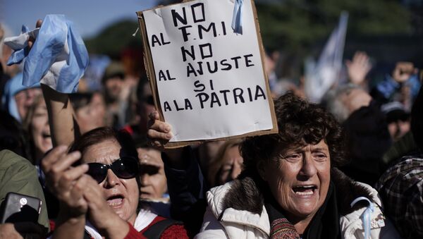 Mulheres gritam contra o presidente argentino Mauricio Macri. Uma delas, no centro, segura uma placa com a mensagem Não ao FMI, não à austeridade, sim à pátria-mãe, em Buenos Aires. Milhares protestaram contra a decisão do governo de pedir socorro ao FMI. Foto de 25 de maio de 2018. - Sputnik Brasil