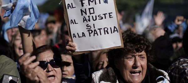 Mulheres gritam contra o presidente argentino Mauricio Macri. Uma delas, no centro, segura uma placa com a mensagem Não ao FMI, não à austeridade, sim à pátria-mãe, em Buenos Aires. Milhares protestaram contra a decisão do governo de pedir socorro ao FMI. Foto de 25 de maio de 2018. - Sputnik Brasil