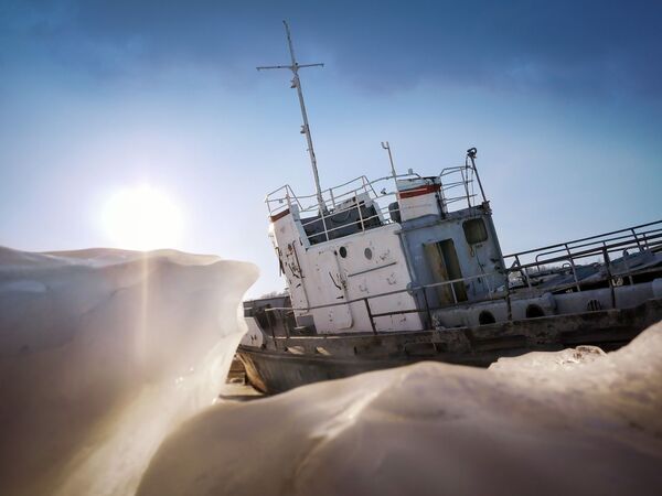 Imagem incrível tirada atrás do gelo mostra um barco de pescagem parado no lago Baikal, na Rússia, em 30 de agosto de 2018 - Sputnik Brasil