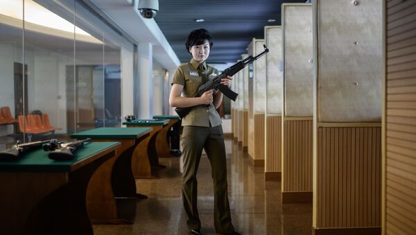 Kim Ju Yang, instrutora de armas de 20 anos de idade, com uma metralhadora de produção norte-coreana em um campo de tiro de Pyongyang - Sputnik Brasil
