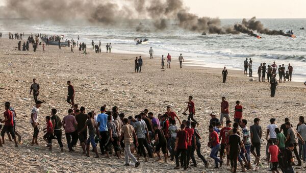 Palestinos carregam homem ferido durante confrontos com soldados israelenses na Faixa de Gaza, em 2 de setembro de 2018 - Sputnik Brasil