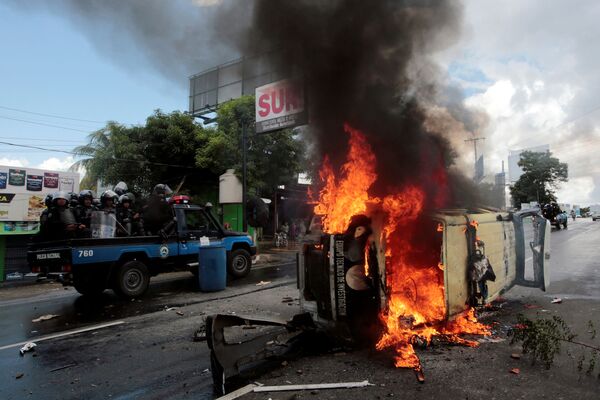 Policiais de choque passam por carro da polícia durante protesto contra o governo do presidente da Nicarágua, Daniel Ortega, na capital Manágua - Sputnik Brasil