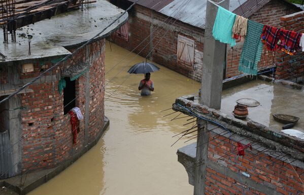 Homem no meio de uma rua inundada na cidade indiana de Siliguri, em 10 de setembro de 2018 - Sputnik Brasil