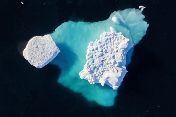 Iceberg flutua em um fiorde (golfo encurvado e profundo que se situa entre montanhas muito altas e íngremes) perto da cidade de Tasiilaq, no sudeste da Groenlândia, em 19 de junho de 2018 - Sputnik Brasil