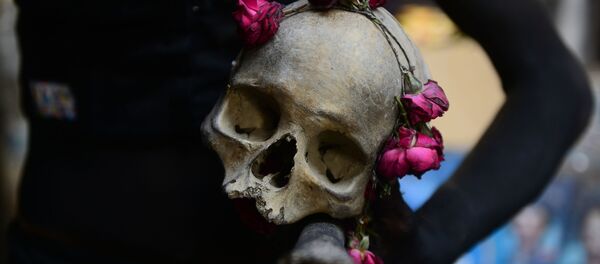 Homem segura caveira com rosas nas mãos durante ritual religioso em Allahabad, na Índia (imagem de arquivo) - Sputnik Brasil