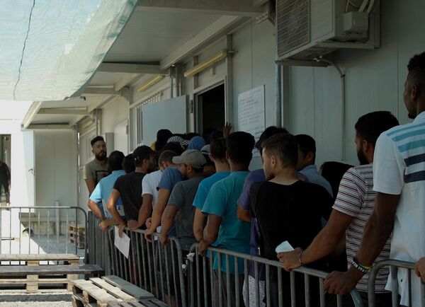 Migrantes esperando na fila para serem atendidos no campo de refugiados  - Sputnik Brasil