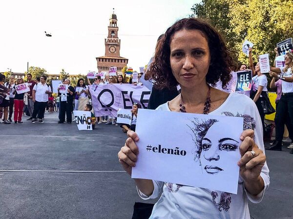 No sábado, 29 de setembro, em Milão, na Itália, mulher segura cartaz com o rosto de Marielle Franco e a frase Ele Não, símbolo do movimento Mulheres Contra Bolsonaro. - Sputnik Brasil