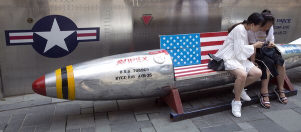 Mulheres chinesas olham para um smartphone, sentadas em um banco na forma de um míssil, em Pequim - Sputnik Brasil