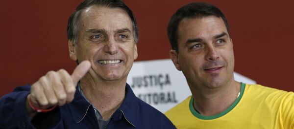 Candidato à presidência do Brasil, Jair Bolsonaro (PSL), vota no Rio de Janeiro junto ao seu filho Flávio, em 7 de outubro de 2018 Candidato à presidência do Brasil, Jair Bolsonaro (PSL), vota no Rio de Janeiro junto ao seu filho Flávio, em 7 de outubro de 2018 - Sputnik Brasil
