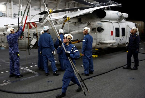 Membro da tripulação trabalha em um helicóptero SH-60K Sea Hawk no convés do hangar do navio japonês Kaga - Sputnik Brasil