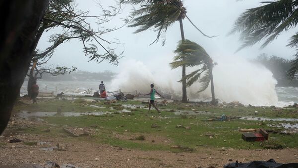 In this image provided by UNICEF Pacific people walk along the shore where debris is scattered in Port Vila, Vanuatu, Saturday, March 14, 2015, in the aftermath of Cyclone Pam - Sputnik Brasil