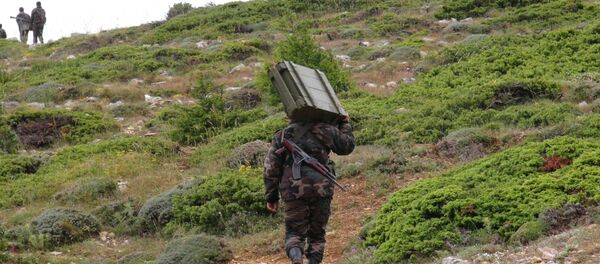 Soldado do Exército sírio carregando armamento ao norte da província síria de Latakia - Sputnik Brasil