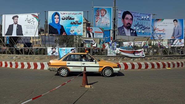 Um veículo circula em frente a cartazes eleitorais de candidatos parlamentares instalados durante o primeiro dia da campanha eleitoral em Cabul, Afeganistão. - Sputnik Brasil