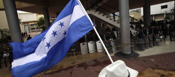 Homem ergue bandeira de Honduras durante protesto em Tegucigalpa, em 5 de novembro de 2009 - Sputnik Brasil