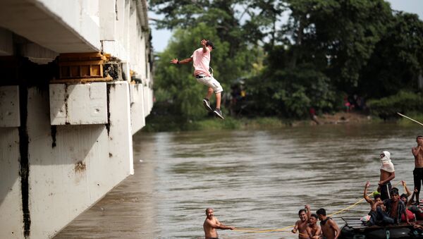 Um migrante hondurenho salta da ponte que liga México e Guatemala para evitar o posto fronteiriço em Ciudad Hidalgo - Sputnik Brasil