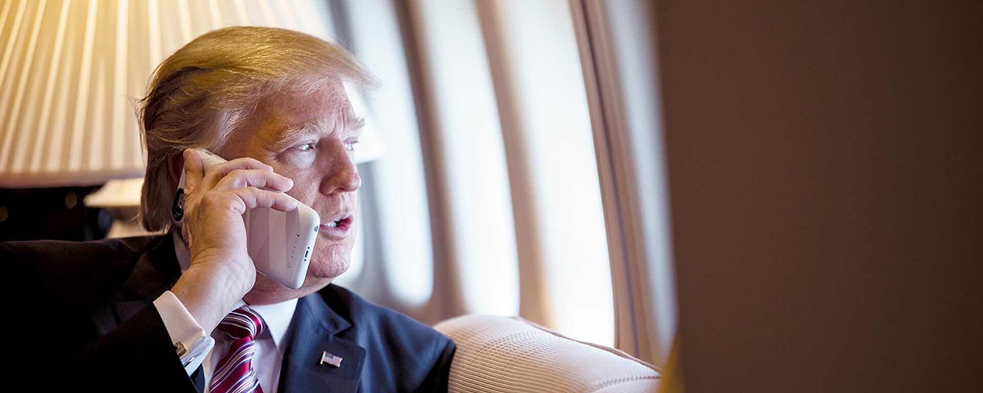 O presidente Donald Trump fala ao telefone a bordo do avião presidencial Air Force One. - Sputnik Brasil, 1920, 12.04.2025
