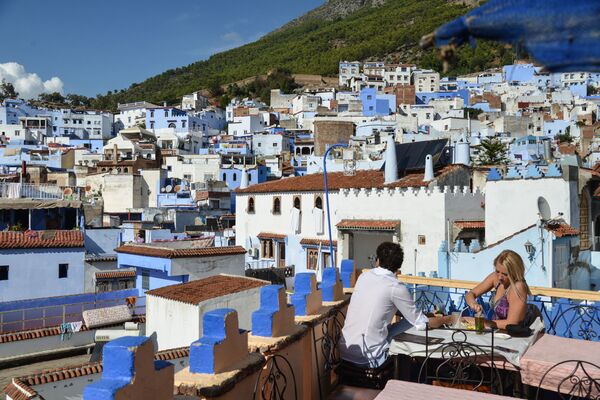 Pessoas tomando refeição no terraço de uma cidade de Marrocos - Sputnik Brasil