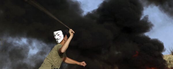 Manifestante usando máscara arremessa pedras contra as tropas israelenses perto da fronteira da Faixa de Gaza com Israel durante protesto, 29 de outubro de 2018 - Sputnik Brasil