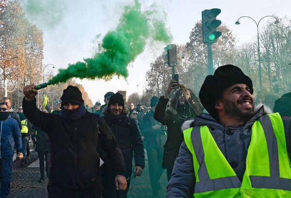 Participantes de protestos dos coletes amarelos contra o aumento dos preços de combustíveis em Paris - Sputnik Brasil