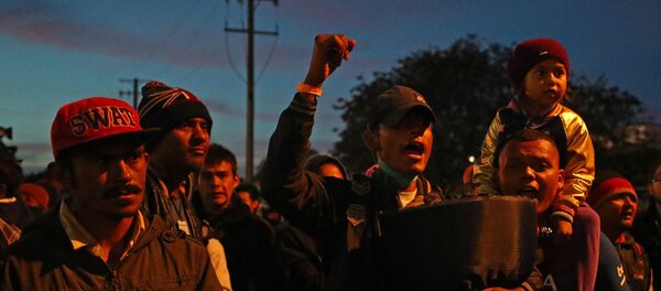 Os migrantes, parte de uma caravana de milhares de pessoas da América Central que tentam chegar aos Estados Unidos, ficam do lado de fora do porto de El Chaparral de passagem de fronteira entre o México e os Estados Unidos. - Sputnik Brasil